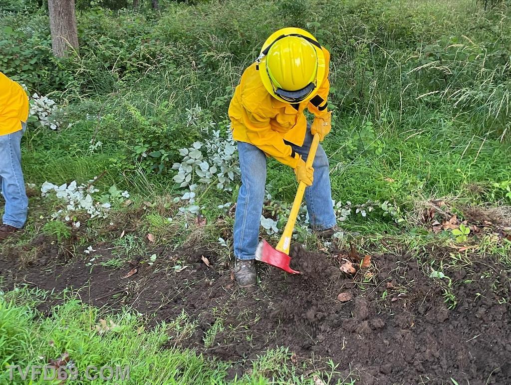 FF Stewart using a Pulaski to cut  a fire line